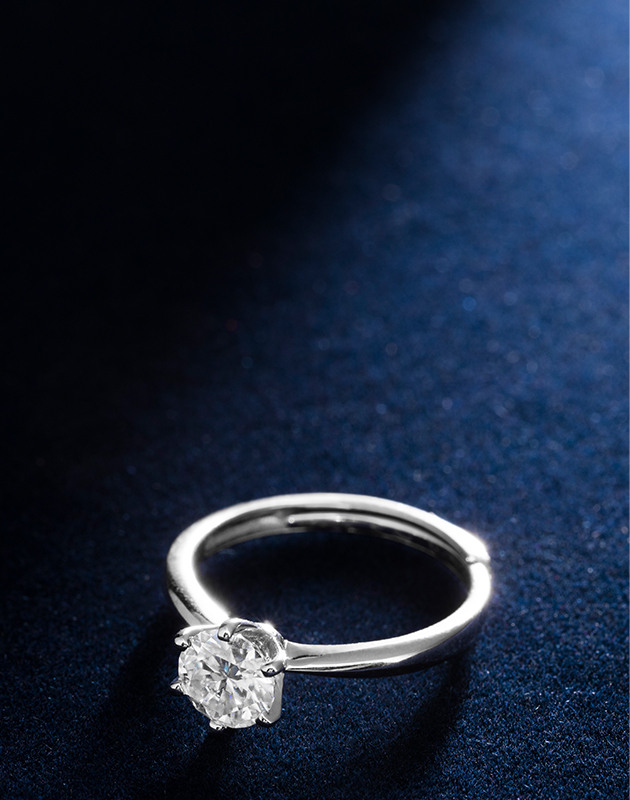 diamond solitaire white gold ring on a backlit dark blue background